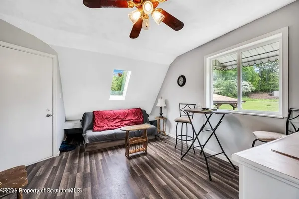 a room with chandelier fan and wooden floor