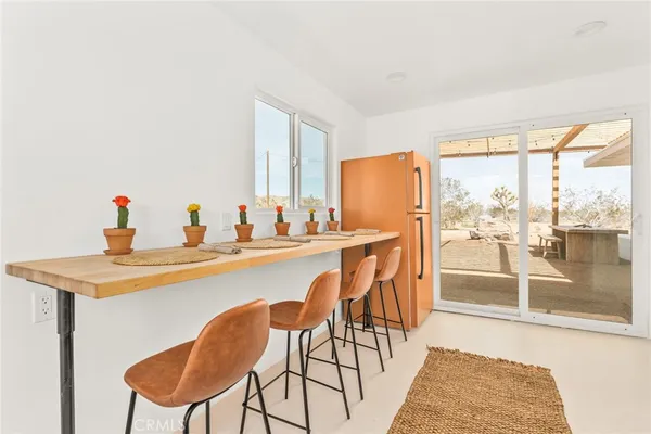 a dining room with furniture and a floor to ceiling window