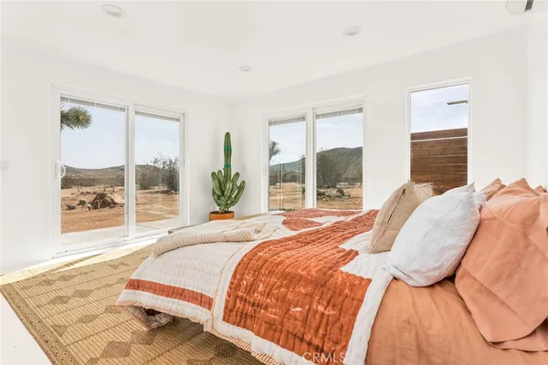 a bedroom with a bed and next to a window