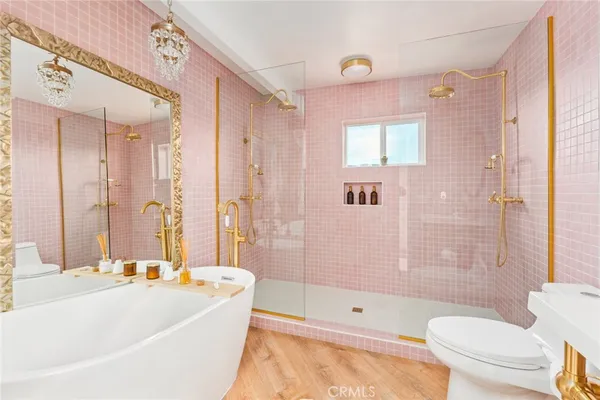 a bathroom with a bathtub shower sink mirror vanity and a toilet
