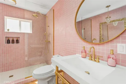 a bathroom with a sink a toilet and a mirror