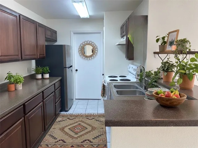 a kitchen with stainless steel appliances kitchen island granite countertop a refrigerator and a stove