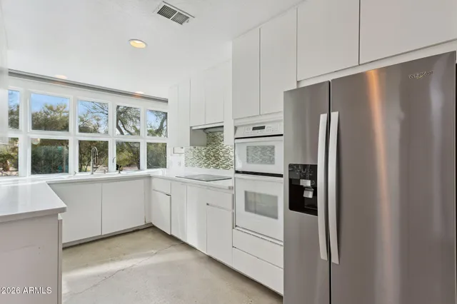 a view of a kitchen with refrigerator and windows