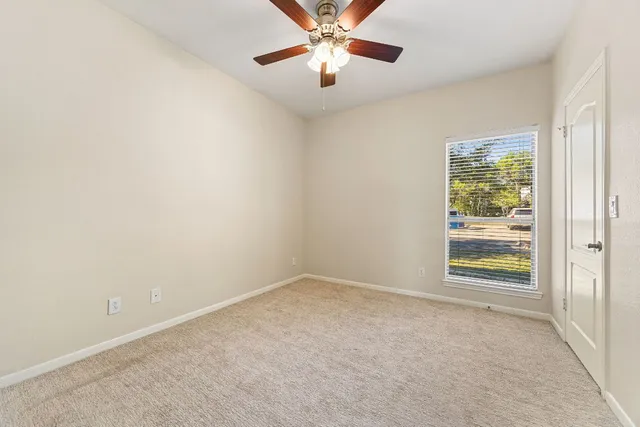 an empty room with closet and windows