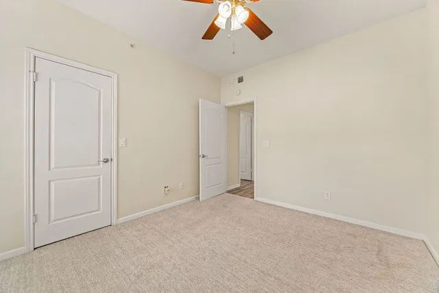 an empty room with chandelier fan