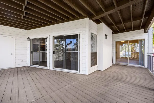 a view of an empty room with wooden floor and windows