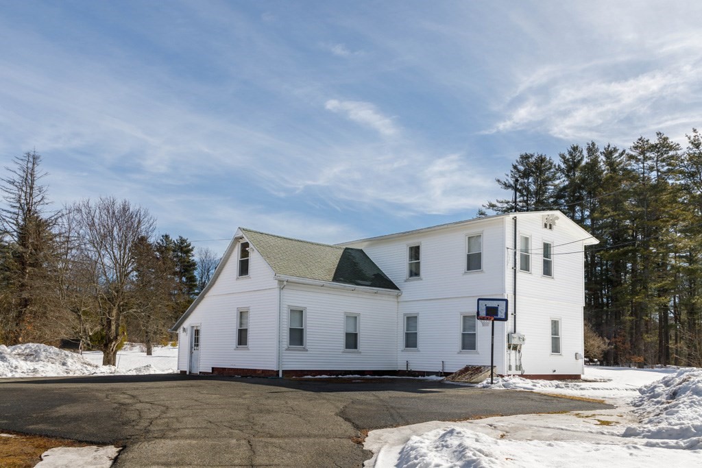 184 Minott Road, Unit 1 Gardner, MA 01440 - Photo 1 of 13 a view of a white house with a yard covered with snow in front of it