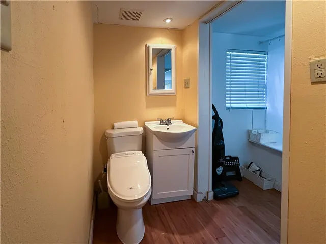 a bathroom with a toilet a sink and mirror