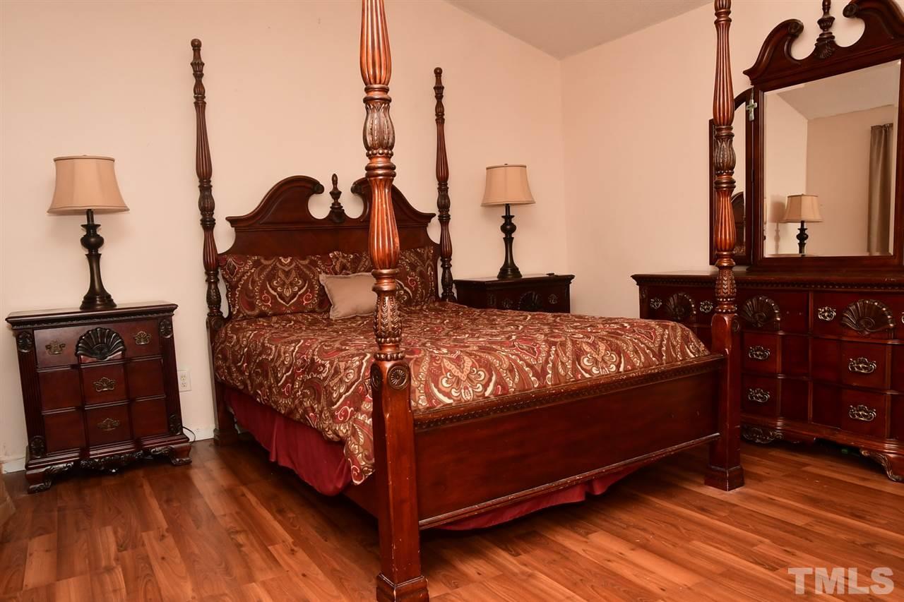 5600 Orchard Gate Way Raleigh, NC 27616 - Photo 13 of 19 a bedroom with a bed a dresser and wooden floor