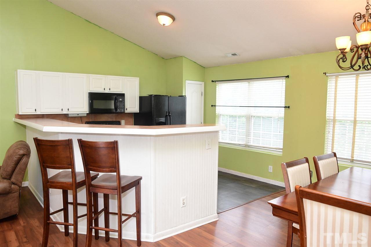 5600 Orchard Gate Way Raleigh, NC 27616 - Photo 8 of 19 a kitchen with stainless steel appliances kitchen island a table chairs in it and a wooden floor