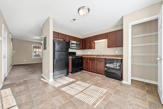 a kitchen with stainless steel appliances granite countertop a refrigerator and a sink
