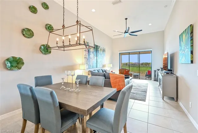 a view of a dining room and livingroom with furniture wooden floor a chandelier