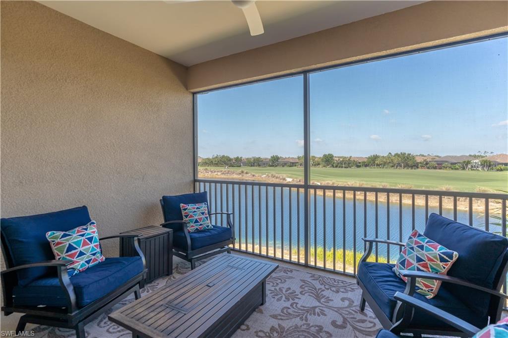 9389 Pocida Court, Unit 202 Naples, FL 34119 - Photo 22 of 38 Sunroom with a balcony, a water view, ceiling fan, and golf course view