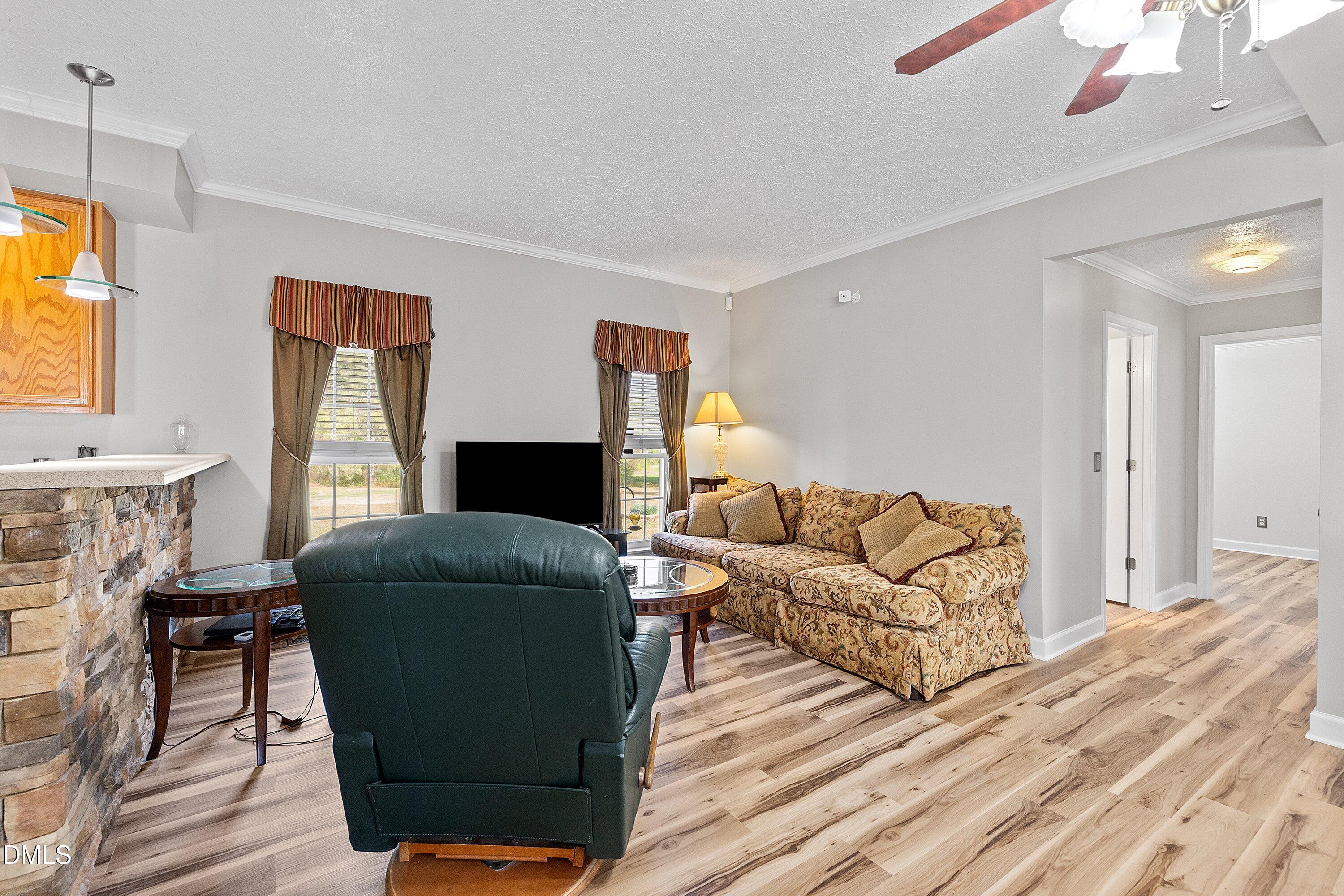 2265 Bud Lipscomb Road Willow Spring, NC 27592 - Photo 12 of 76 a living room with furniture and a flat screen tv