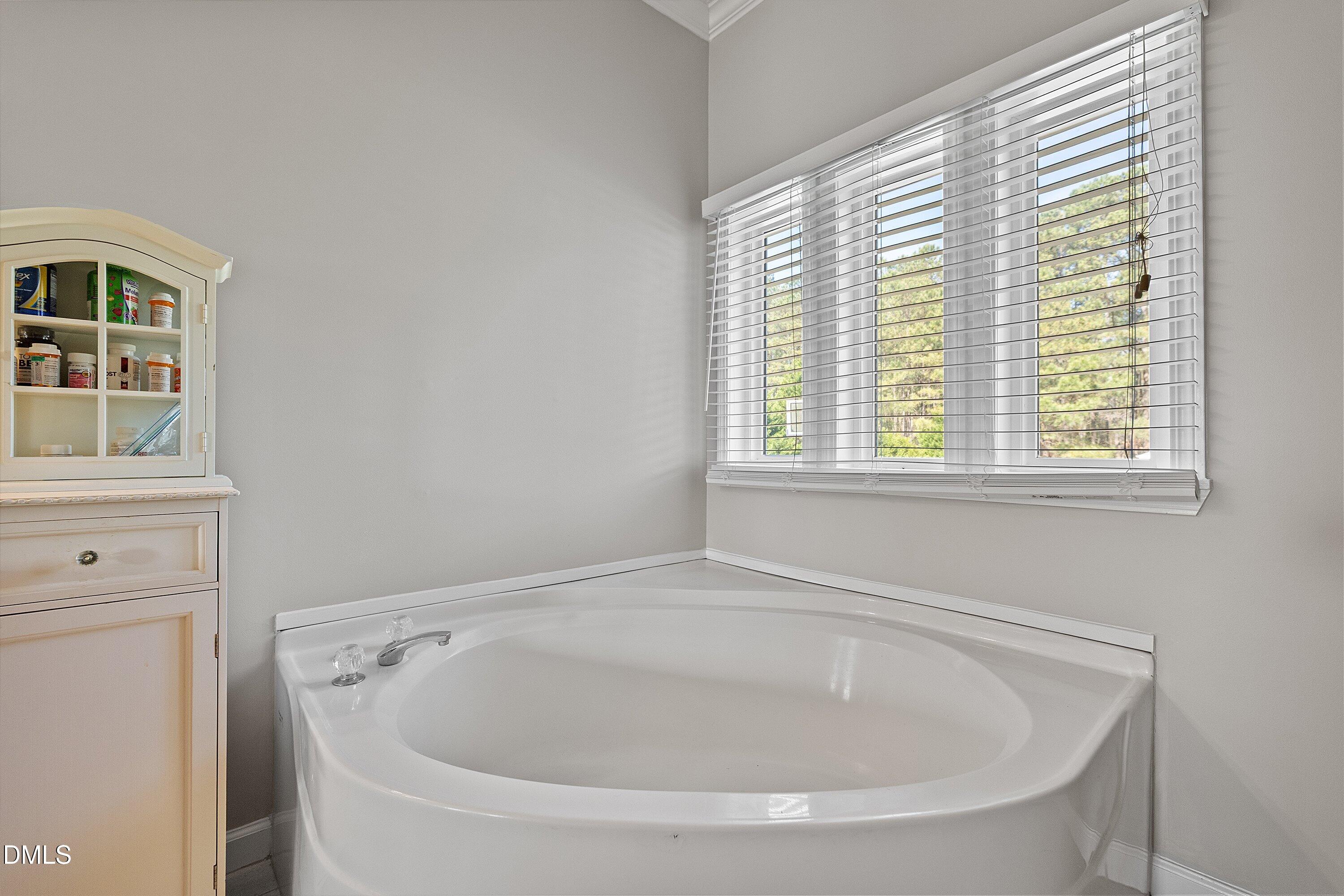 2265 Bud Lipscomb Road Willow Spring, NC 27592 - Photo 27 of 76 a white bath tub sitting in a bathroom next to a window