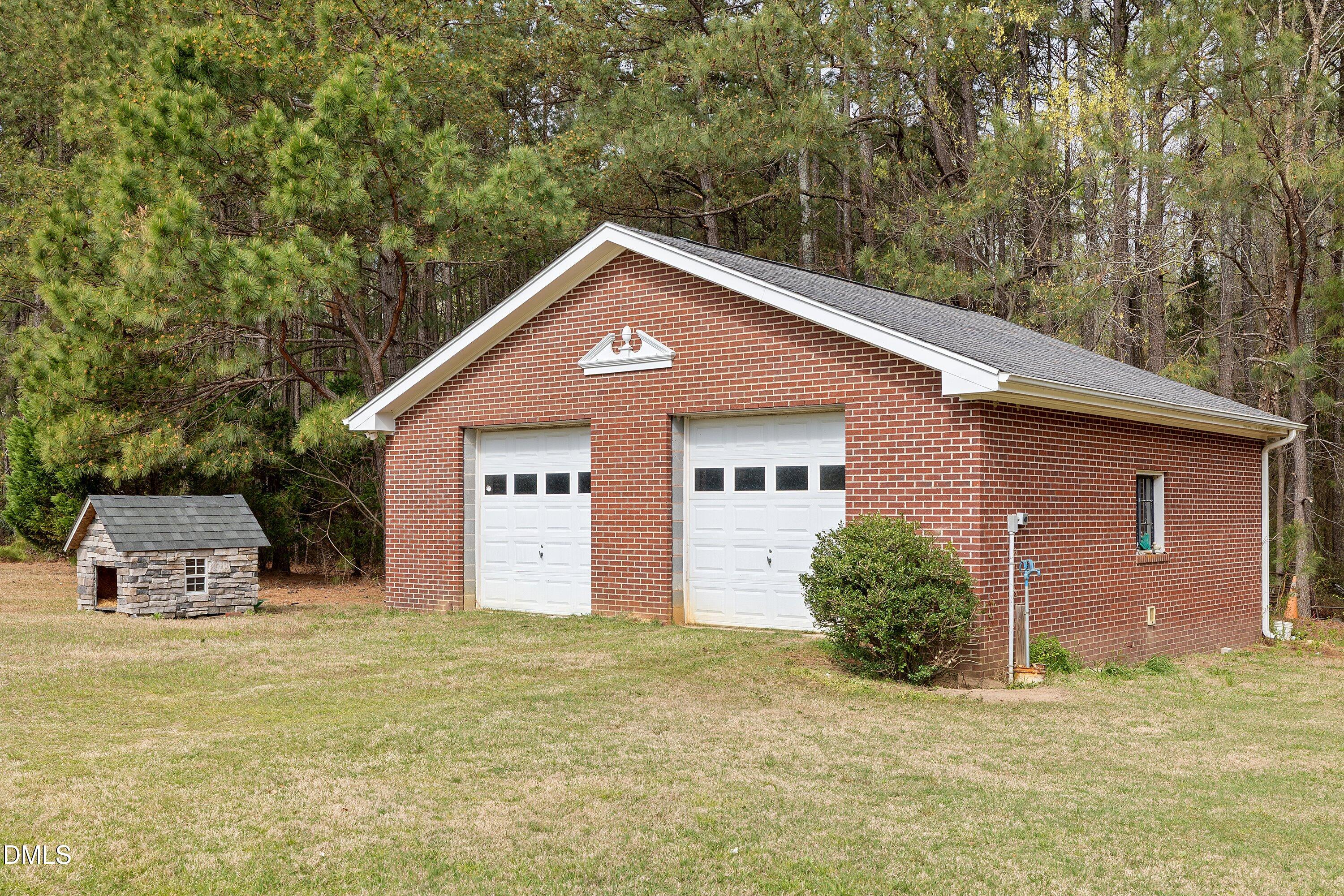 2265 Bud Lipscomb Road Willow Spring, NC 27592 - Photo 50 of 76 a front view of a house with a yard and garage