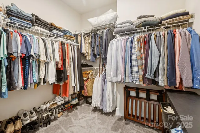 a view of walk in closet with clothes