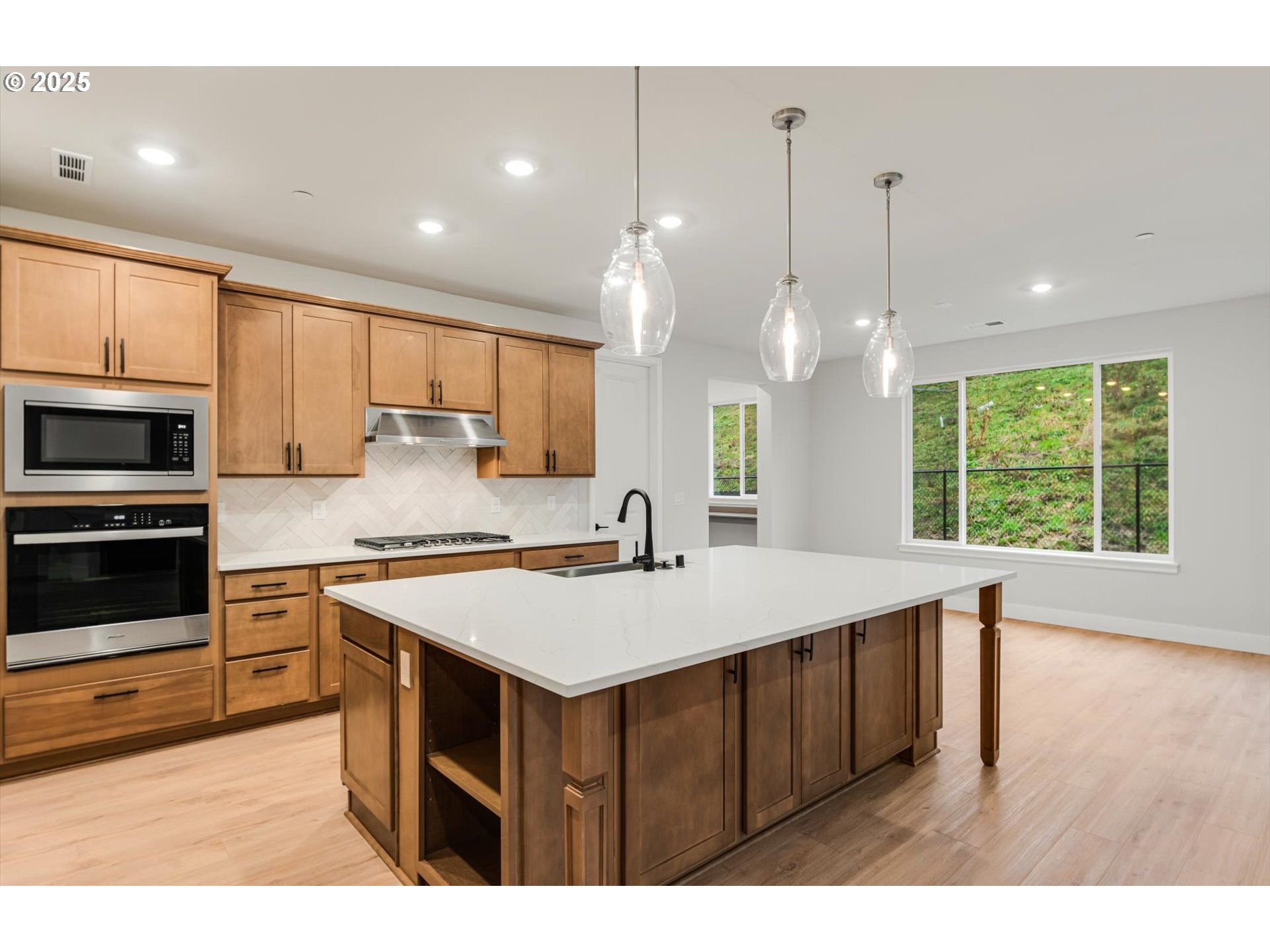 8710 South 3rd Street Ridgefield, WA 98642 - Photo 6 of 22 a large kitchen with kitchen island a stove a sink a center island and wooden floor