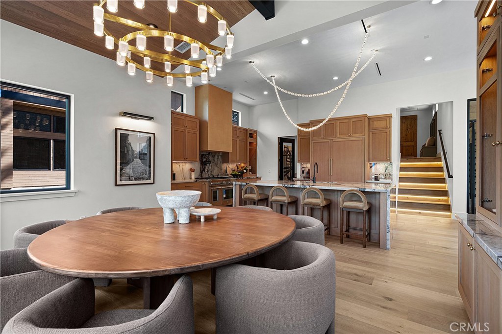 9348 Nine Bark Road Truckee, CA 96161 - Photo 35 of 58 a dining room with wooden floor a chandelier a wooden table and chairs