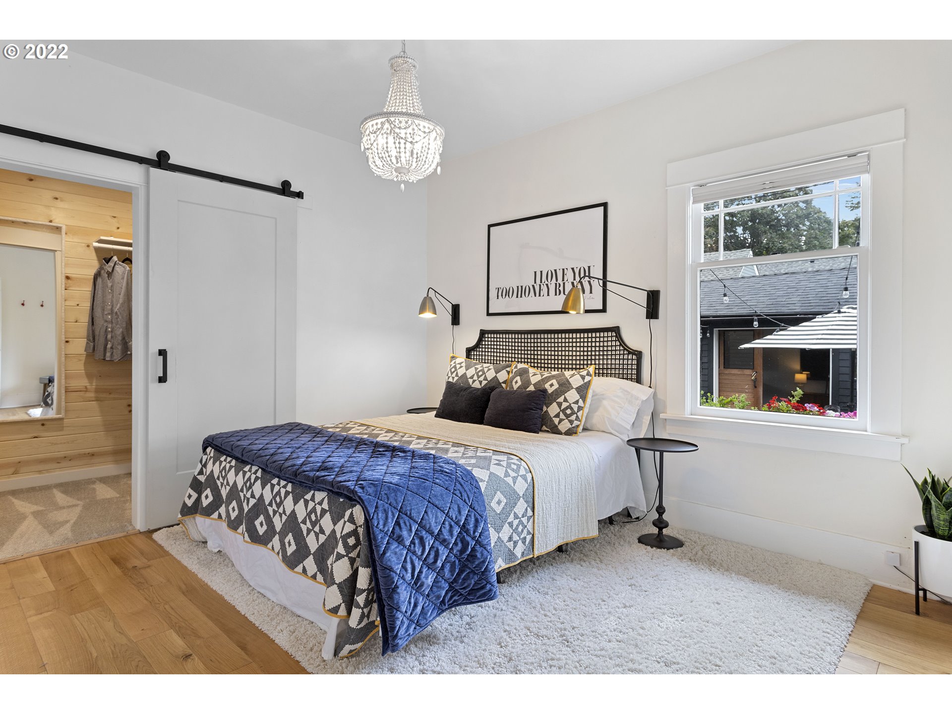 6429 North Commercial Avenue Portland, OR 97217 - Photo 12 of 32 a bedroom with a bed and a chandelier