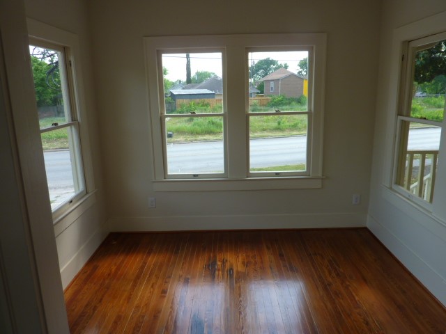 4105 McKinney Street, Unit B Houston, TX 77023 - Photo 11 of 25 an empty room with wooden floor and windows