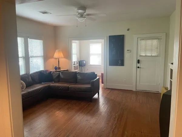 a living room with furniture and a wooden floor