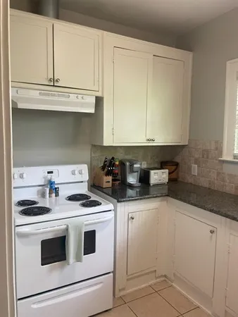 a kitchen with granite countertop white cabinets and white appliances