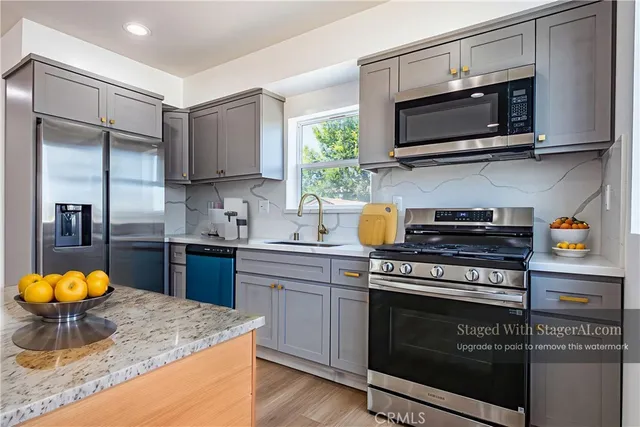 a kitchen with stainless steel appliances granite countertop a stove a sink and a microwave