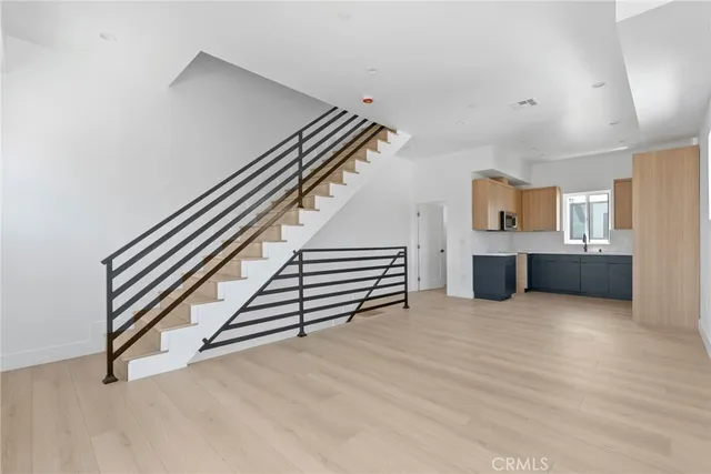 an empty room with wooden floor and stairs