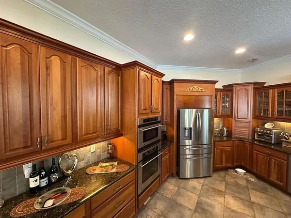 a kitchen with granite countertop a refrigerator and furniture