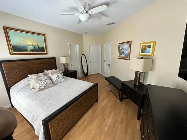 a bedroom with a bed and a painting on the wall