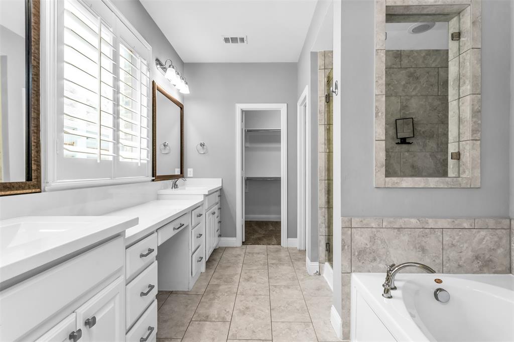 15713 Canyon Ridge Prosper, TX 75078 - Photo 22 of 38 Spacious bathroom featuring an expansive double vanity with white cabinetry and integrated sinks, a built-in soaking tub, a separate shower with tile surround, and neutral tile flooring