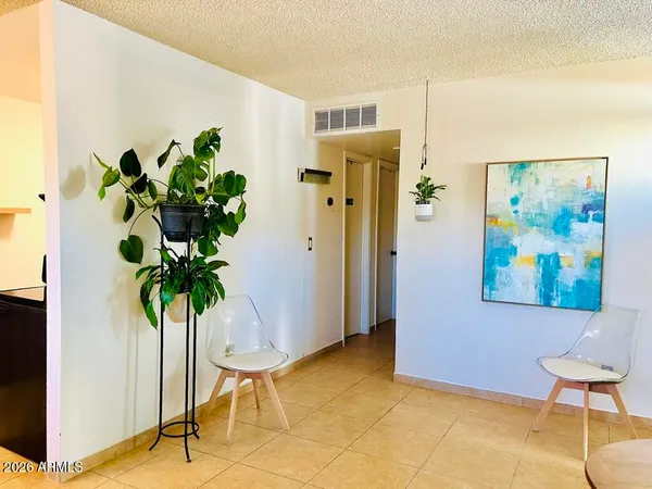 a view of a hallway with paintings on the wall and a potted plant