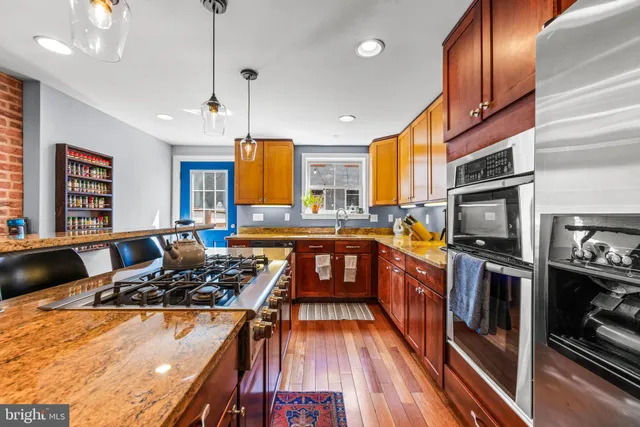 a kitchen with stainless steel appliances granite countertop a stove a sink dishwasher and a refrigerator