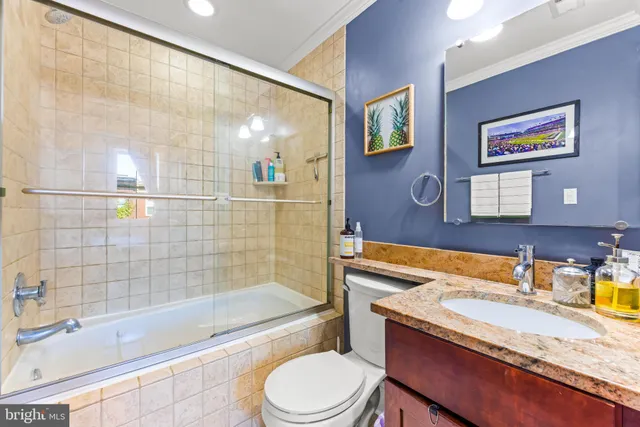 a bathroom with a granite countertop sink toilet and shower