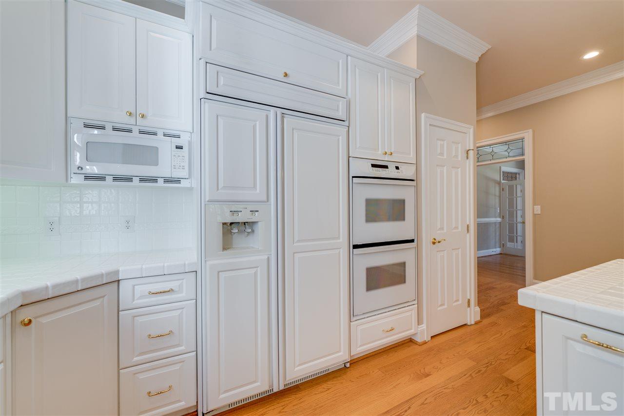 7233 Kemp Road Raleigh, NC 27613 - Photo 8 of 25 a kitchen with white cabinets and white stainless steel appliances