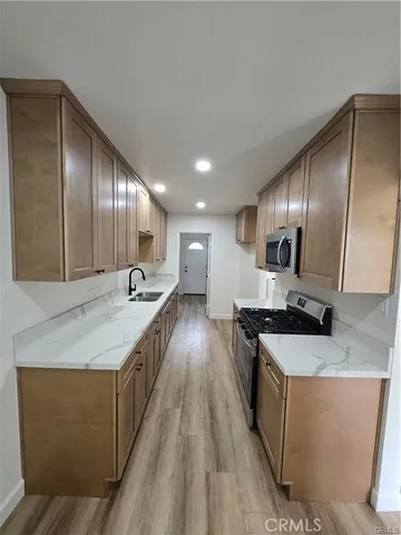 a large kitchen with stainless steel appliances granite countertop a lot of counter space and wooden floor
