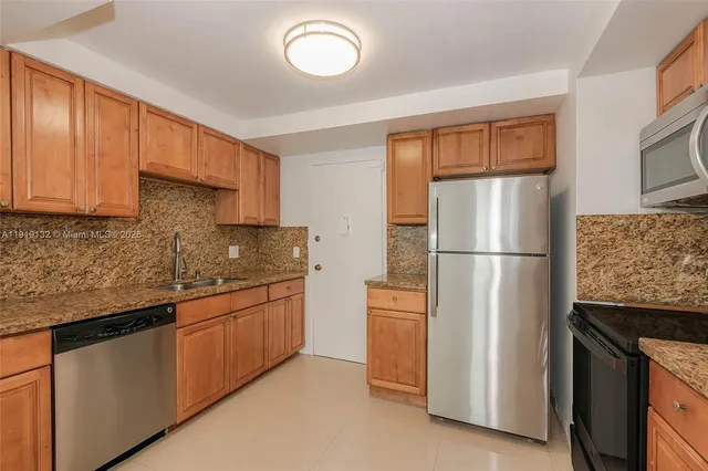 a kitchen with stainless steel appliances granite countertop a refrigerator and a stove top oven