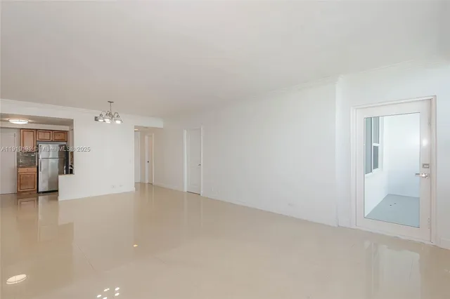 a view of a hallway with wooden floor and a kitchen