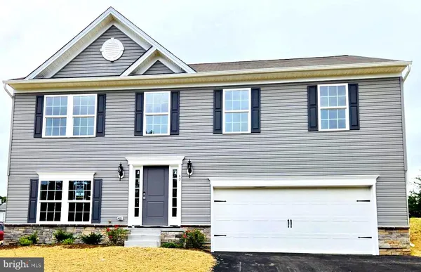 a front view of a house with a garden and garage