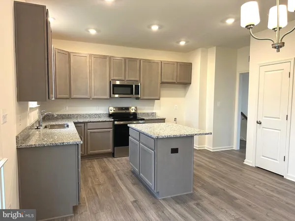 a kitchen with a sink stove top oven and refrigerator