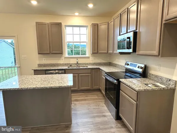 a kitchen with stainless steel appliances granite countertop wooden cabinets a sink and a stove