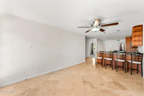 an empty room with windows and fan