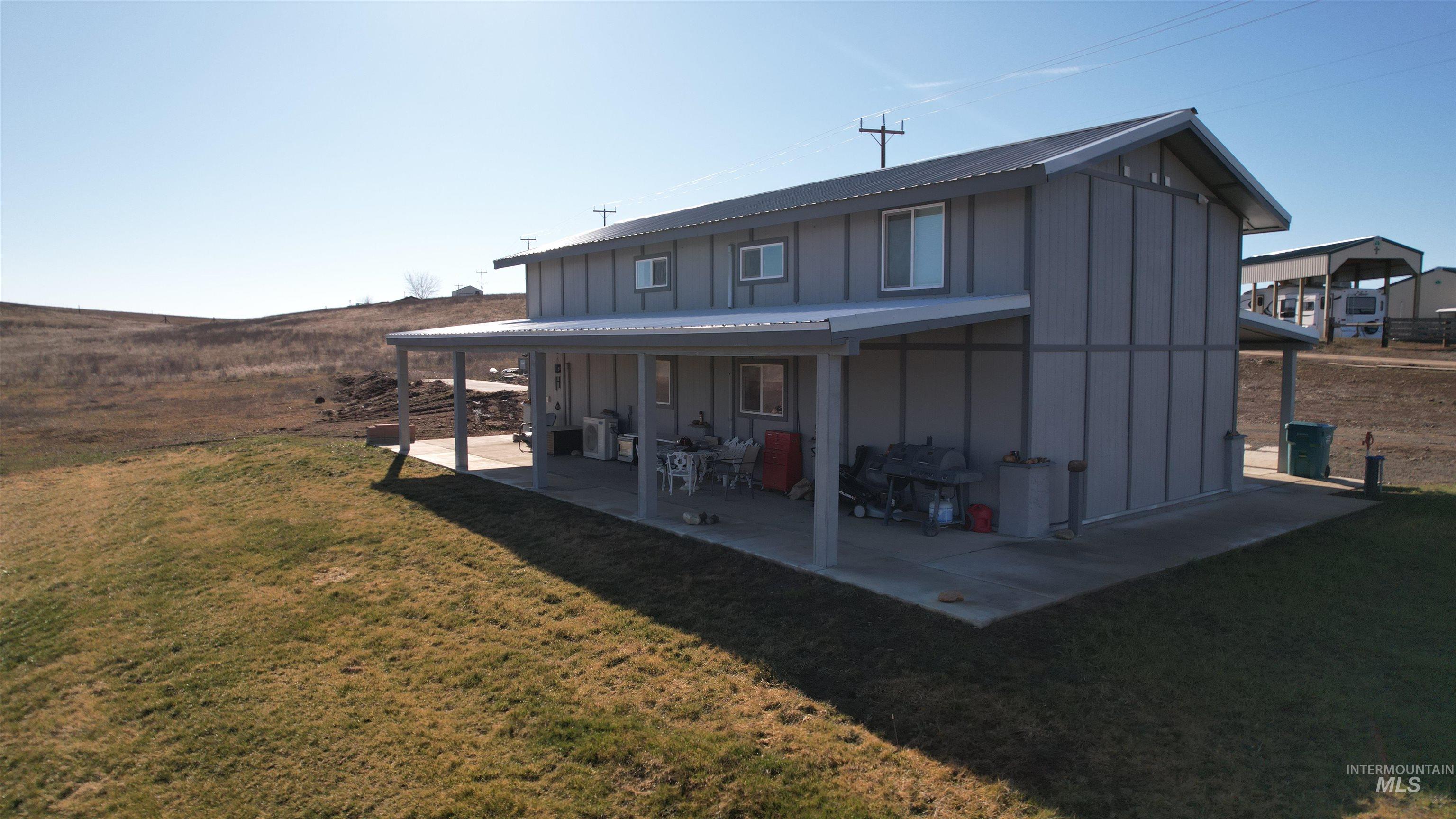 1086 Highland Lane Mesa, ID 83643 - Photo 2 of 45 Back of house featuring board and batten siding, a yard, and a metal roof