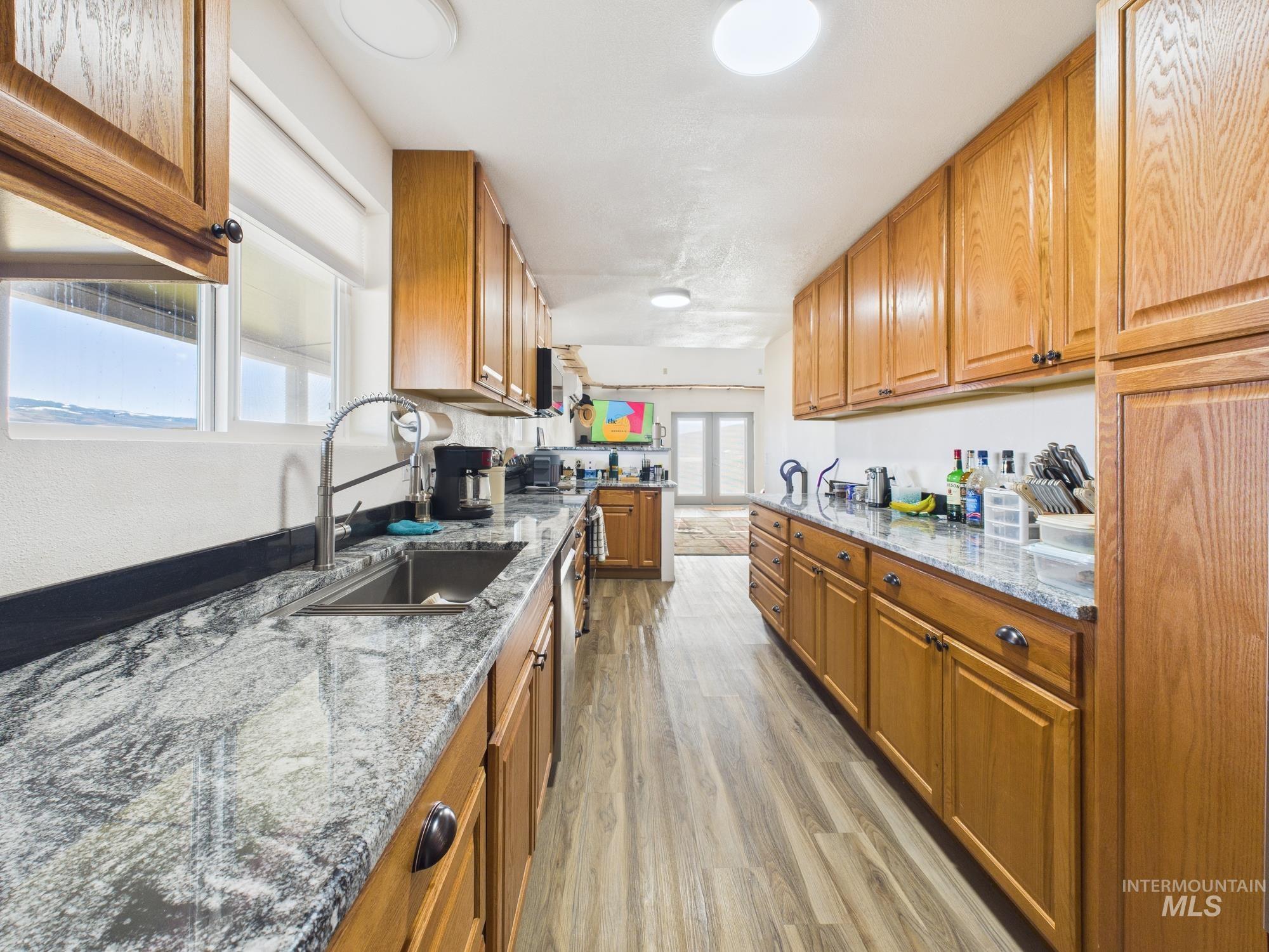 1086 Highland Lane Mesa, ID 83643 - Photo 9 of 45 Kitchen featuring light stone countertops, wood finish cabinets, and light wood-style floors