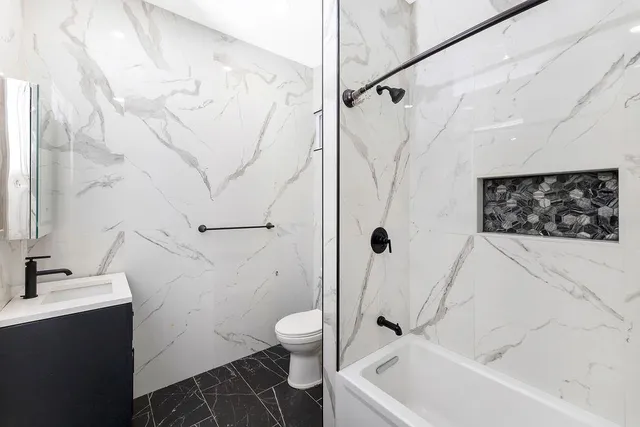 a bathroom with a sink a toilet and shower