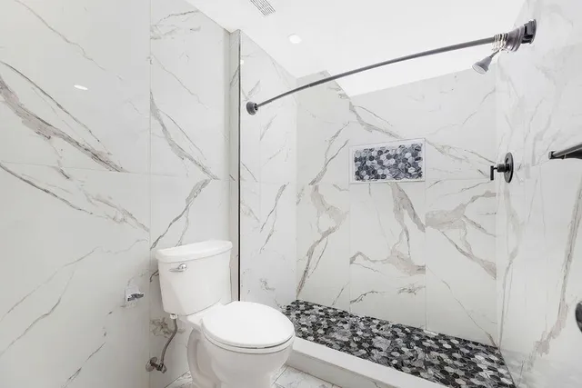a white toilet sitting next to a shower curtain