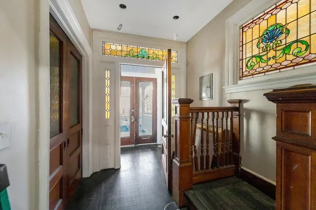 a view of a hallway with wooden floor and staircase