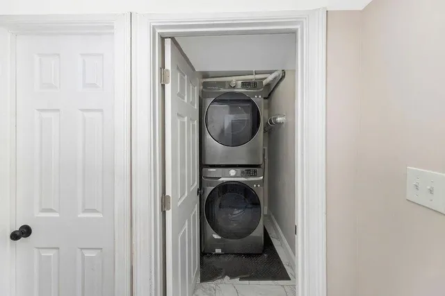 a utility room with dryer washer and a view of bathroom