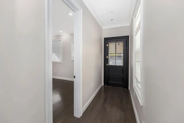 a view of a hallway with wooden floor and closet